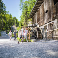 Jugendliche vor einer Wassermühle