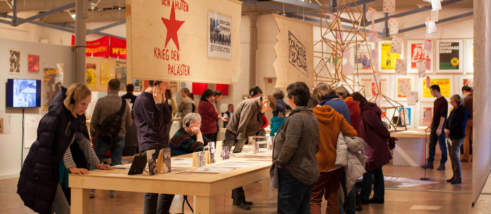 Menschen schauen sich Transparente in einer Ausstellung an