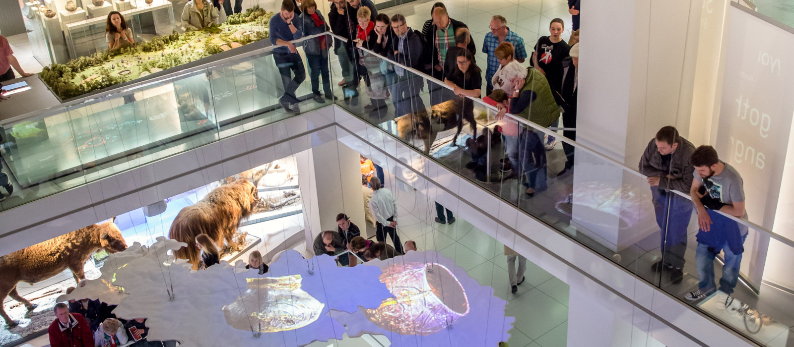 Einblick in eine mehrgeschossige Ausstellung mit schwebender Karte