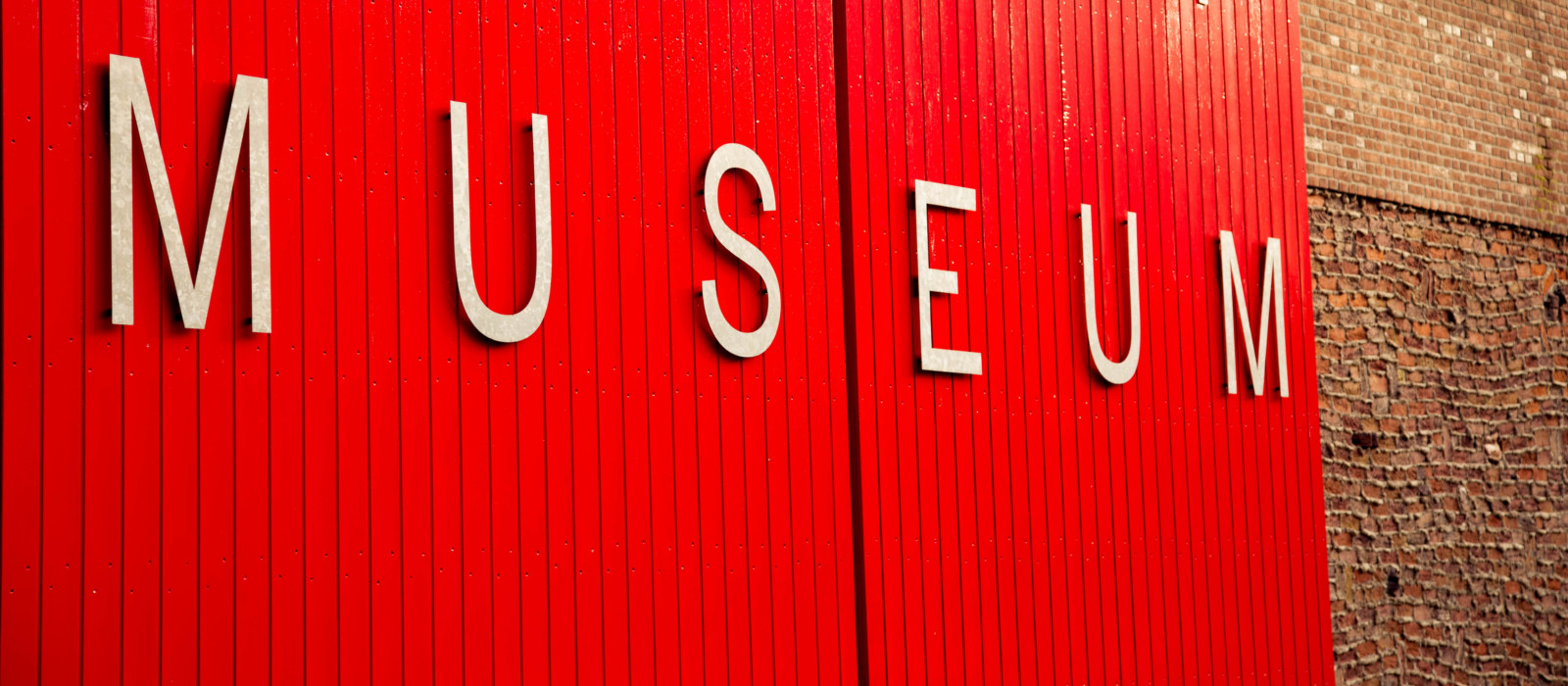 Fassade mit Museumsaufschrift auf rotem Grund