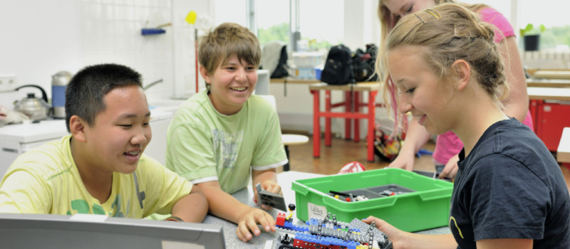 Kindergruppe beim Zusammenbauen eines technischen Gerätes mit Lego
